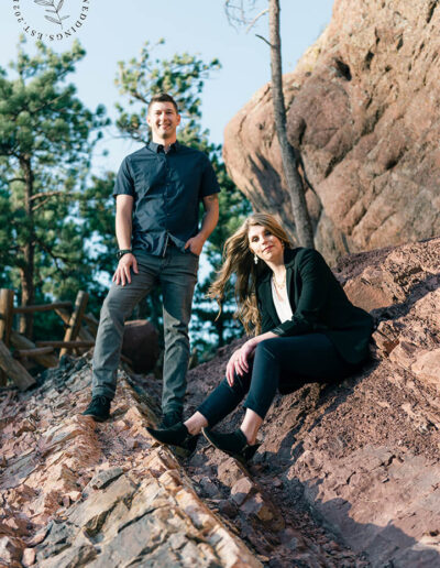 man and woman posing on rocks for marketing photo