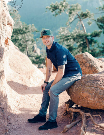 man sitting on a rock wearing a hat